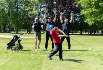 Initiation de golf pour un jeune du collège Saint-Jacques, entourés de joueurs enthousiastes 