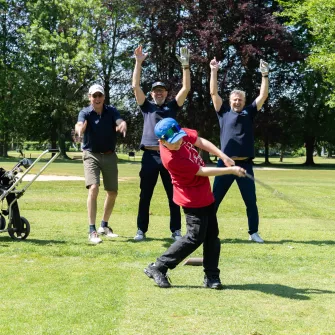Initiation de golf pour un jeune du collège Saint-Jacques, entourés de joueurs enthousiastes 